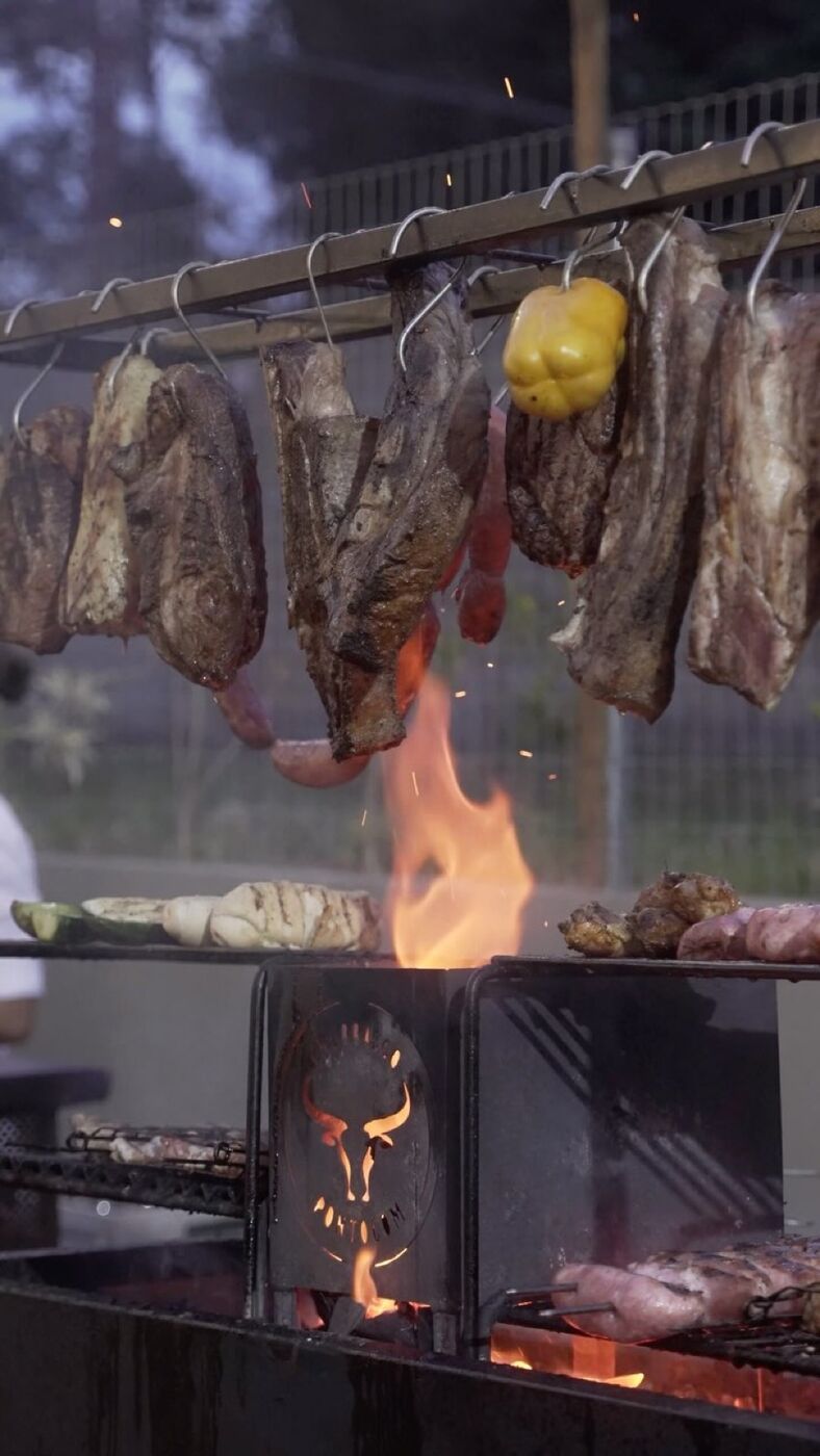 Carnes penduradas na trempe durante evento de casamento