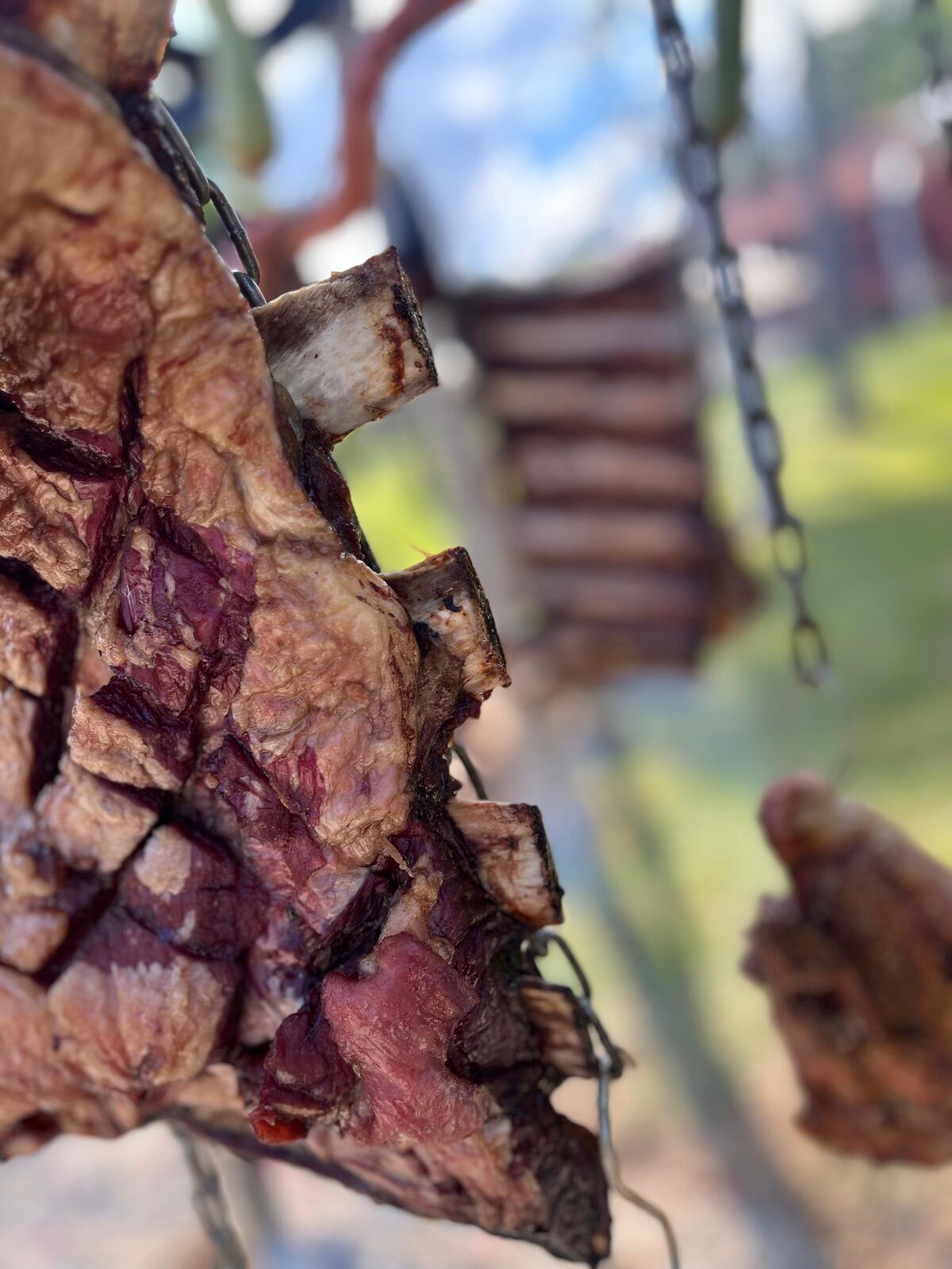 Costela assando pendurada na corrente do fogo de chão