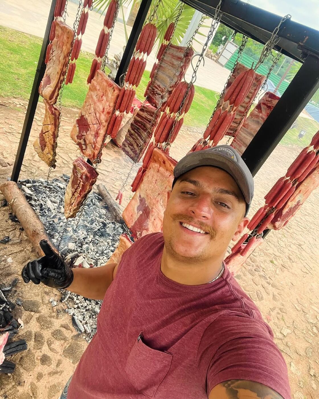 Espetos de carne fincados em volta do fogo de chão